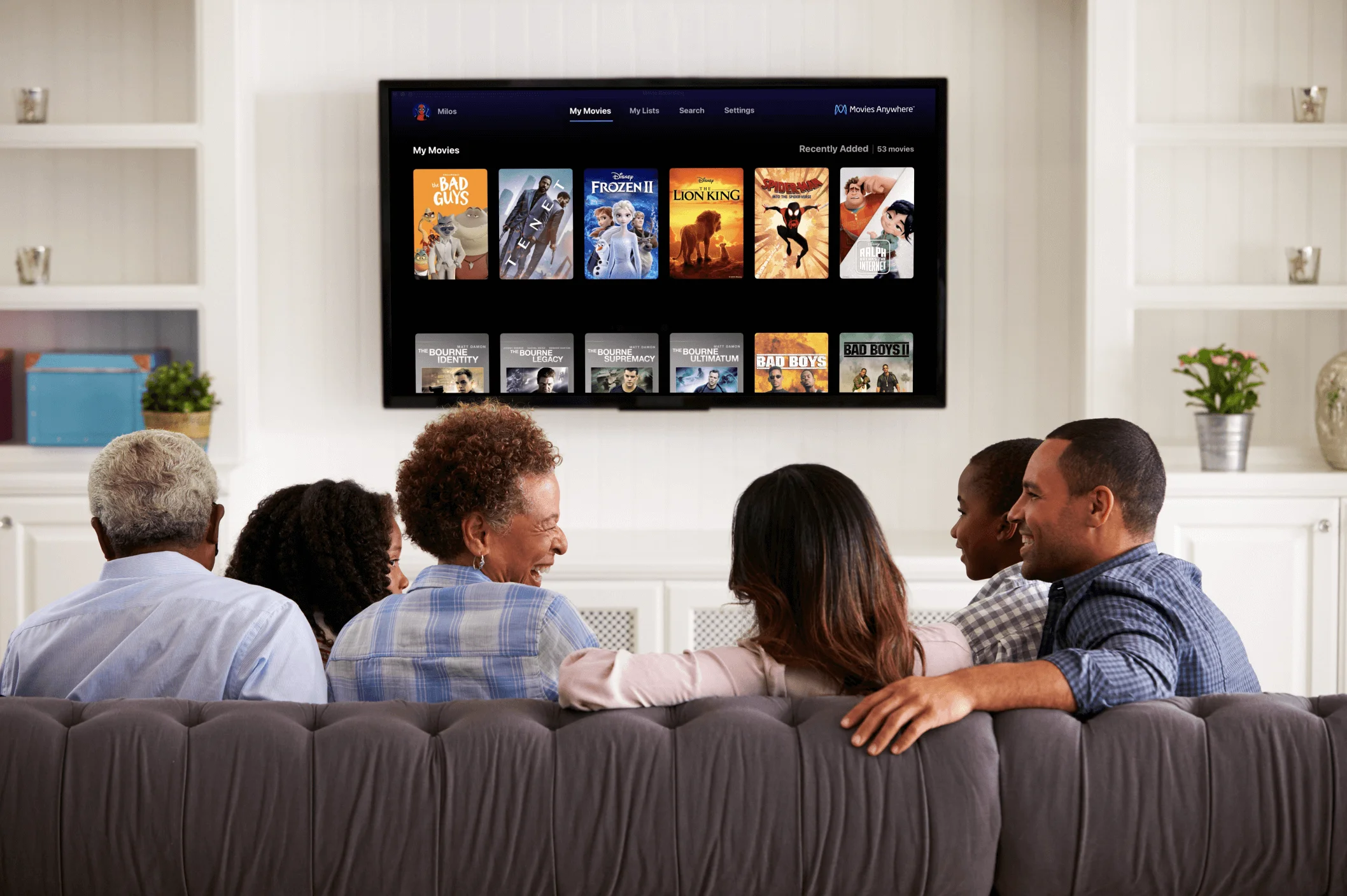 Family sitting on the couch in the living room about to watch a movie using Disney's Movies Anywhere platform